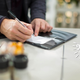 A businessman signs a restaurant check